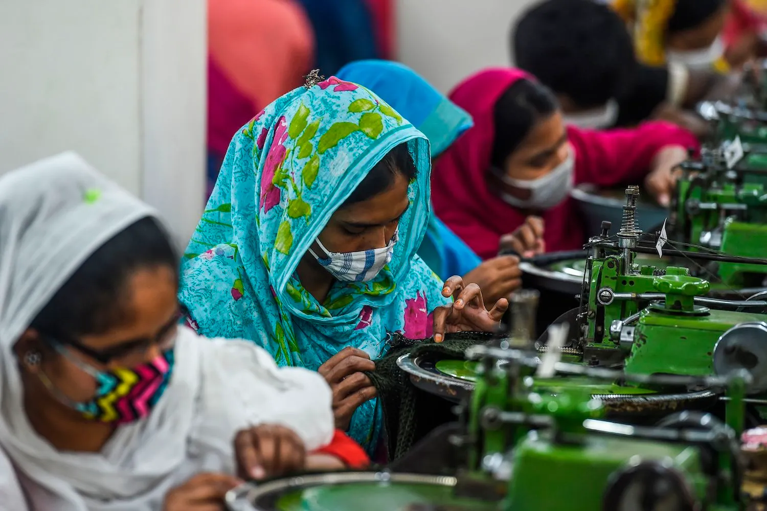 Factory floor with workers cutting and preparing fabric for bulk production
